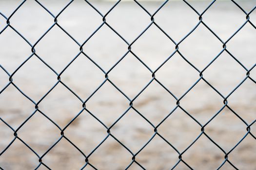 Stretched metal mesh on a blurred background . Fence from a metal grid