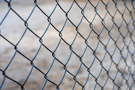 Stretched metal mesh on a blurred background . Fence from a metal grid