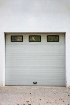 White garage door. Automatic gate with three windows. Wood texture
