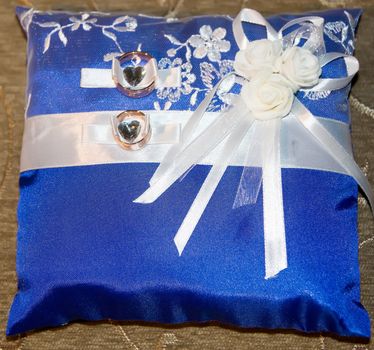 Wedding rings on a blue wedding pillow. In anticipation of marriage