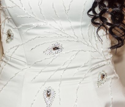 Part of the bride's white dress is decorated with embroidery