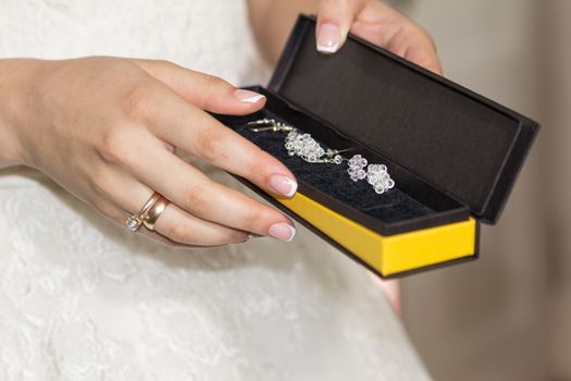 The bride holds jewelry in her hands. Jewelry of the bride. Preparing for the wedding. Box with jewelry in the hands of the bride