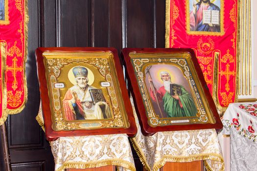 Two icons in beautiful frames stand side by side in the church