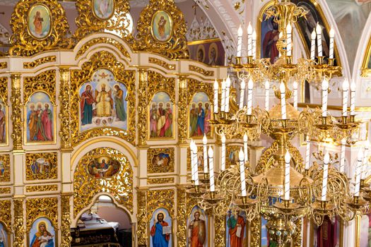 Large chandelier on the background of the iconostasis with icons in the Christian church.