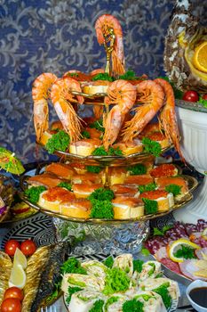 Shrimp and sandwiches with red caviar decorated with greens