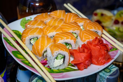 Sushi with red fish. Sushi plate, wasabi and sushi sticks