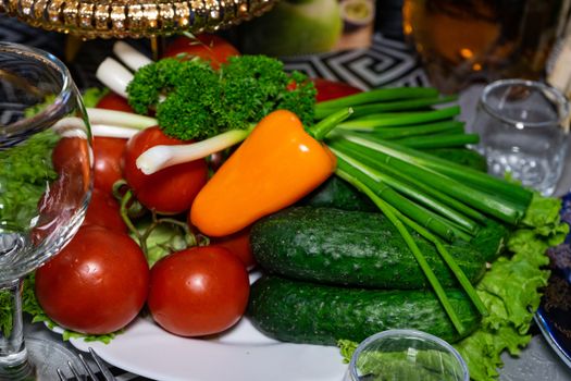 Fresh vegetables on a plate. Vegetarian food. Tomatoes, cucumbers, onions, parsley