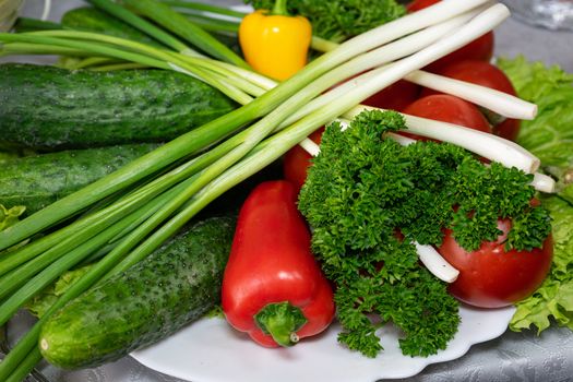 Fresh vegetables on a plate. Vegetarian food. Tomatoes, cucumbers, onions, parsley