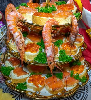 Shrimp and sandwiches with red caviar decorated with greens