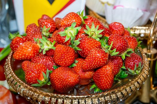 Red fresh strawberries lie on a slide on a beautiful plate