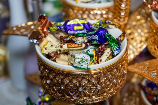 Ukraine, Vinnytsia - May 23, 2020. A variety of candies in a golden bowl