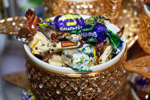 Ukraine, Vinnytsia - May 23, 2020. A variety of candies in a golden bowl