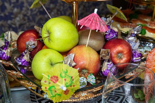 Ukraine, Vinnytsia - May 23, 2020. Fruits and candies on a plate. Apples, kiwi and candy on a plate