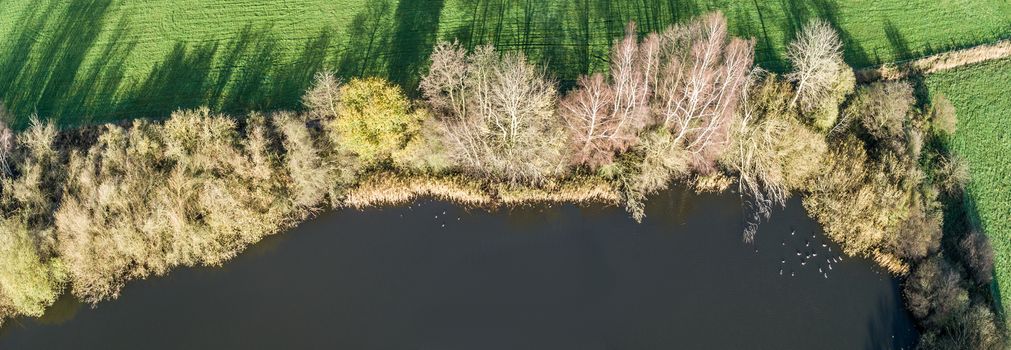 Composite panorama of aerial photos from the bank of a pond in Lower Saxony, Germany, taken with the drone from the air