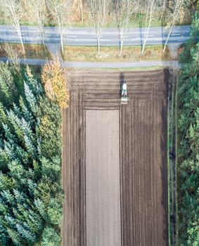 Vertically aligned aerial photograph taken with the drone of an area of arable land treated by a tractor