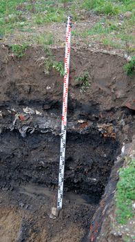 Former rubbish dump in the excavation pit, black discoloured and contaminated soil, old deposit in a construction area for residential buildings