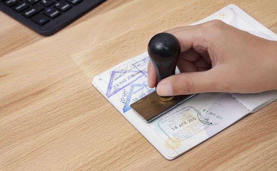 Immigration control officer will arrival stamp in the passport at the airport. Visa stamping. Passport or visa application. Travel immigration stamp