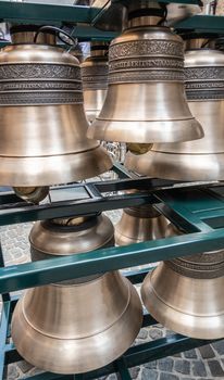 Bruges, Flanders, Belgium -  June 15, 2019: Closeup of a few heavy metal and shiny Petit and Fritsen bells of carillon on square inside Belfry.