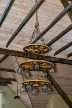 Large modern chandelier in antique style. Wooden building design. Restored castle. Everlasting everywhere