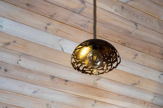 Energy saving lamp on a wooden ceiling. The interior design