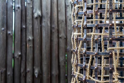 Part of the iron cage for birds is made in the old style. The iron cage is decorated with a rope. Place for text. Place under the inscription.