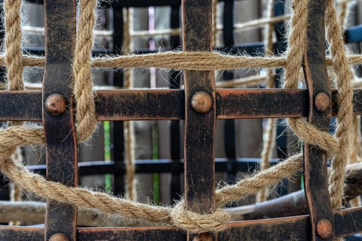 The designer bird cage is made in the old style. The iron cage is decorated with a rope