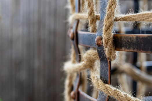 Part of the metal cage braided rope on a brown background. Place for the inscription