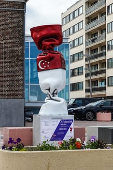 Knokke-Heist, Flanders, Belgium -  June 16, 2019: Knokke-Zoute part of town. Closeup of statue of candy wrapped in Indonesian flag standing on pedestal adjacent to Office of Tourism.