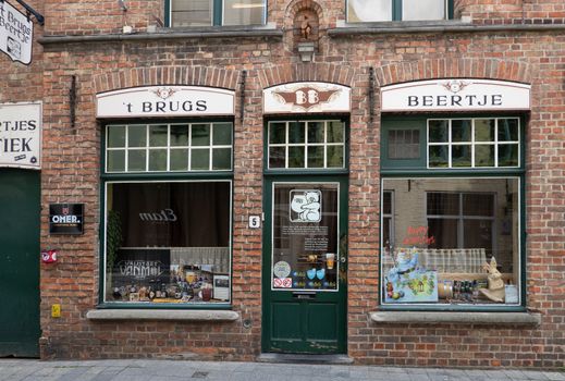 Bruges, Flanders, Belgium -  June 17, 2019: Brugs Beertje is world famous Belgian beer pub and comes in brown-red bricks with two display windows. Statue of bear above door.