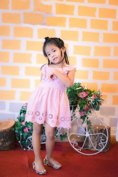 Portrait of little asian girl with vintage wall indoor
