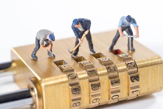 miniature people try to unlock metal security lock key