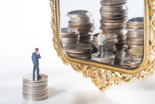 miniature businessmen see financial advisor in the mirror
