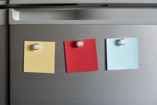 colorful magnet sticky notes on refrigerator door background