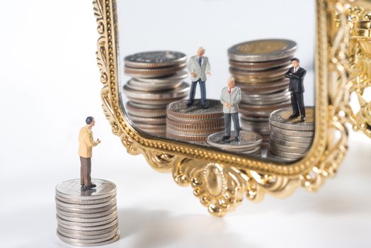 miniature businessmen see wealthy team in the mirror