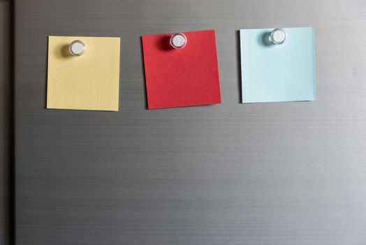 colorful magnet sticky notes on refrigerator door background