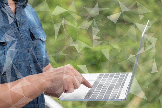 man hand using laptop with natural green leaves background