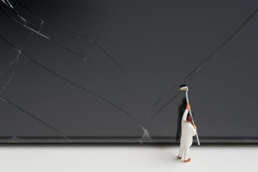 miniature people try to repair a cracked smart phone screen