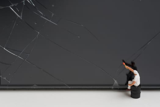 miniature people try to repair a cracked smart phone screen