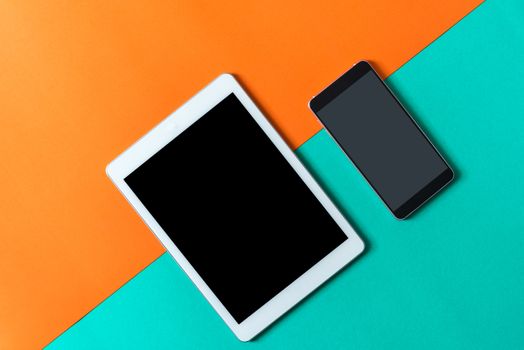 tablet and smart phone on orange green paper background