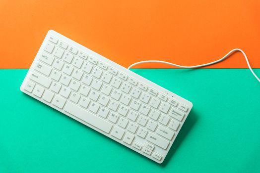 white computer keyboard on orange green background