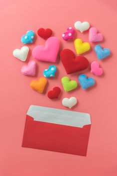 mini heart in heart shape splash from red envelop on pink background