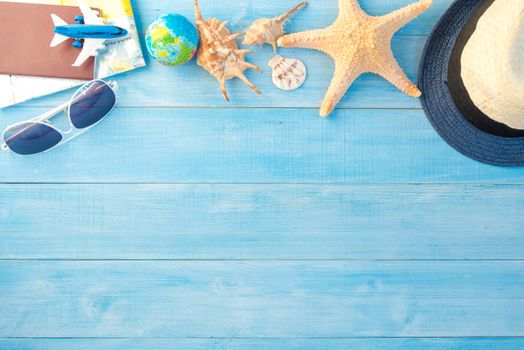 top view of travel accessories on light blue wood plank floor for summer vacation time
