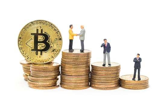 business miniature people shaking hand on stack of dollars coin and gold bitcoin