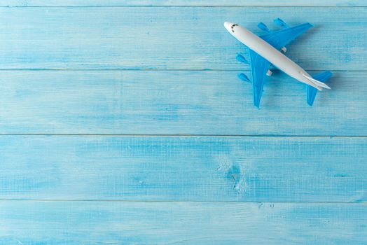 air plane miniature figure on light blue wood plank background