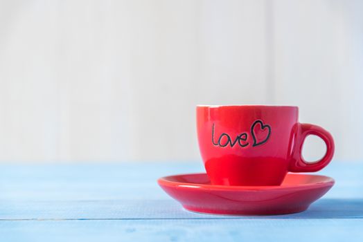 red love coffee cup on light blue wood table