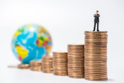 business miniature figure standing on stack of coins and globe figure background