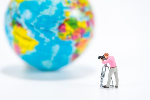 miniature people figure take a photo graph around the world