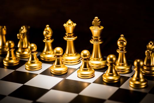 gold chess pieces on a chessboard, business strategy concept