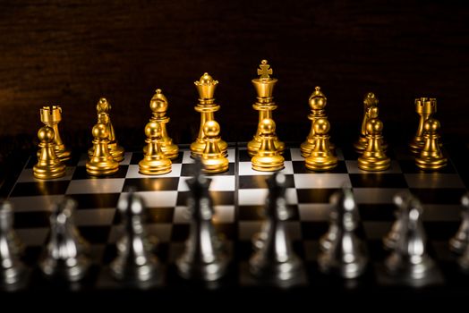 gold chess pieces on a chessboard, business strategy concept