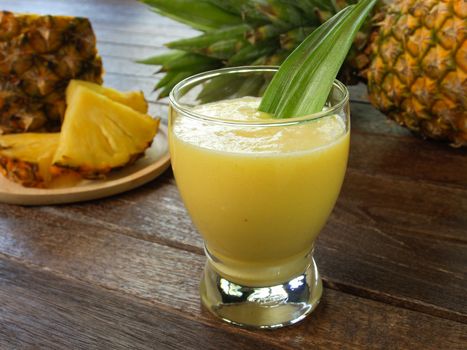 pineapple juice and pineapple on wood table. for health